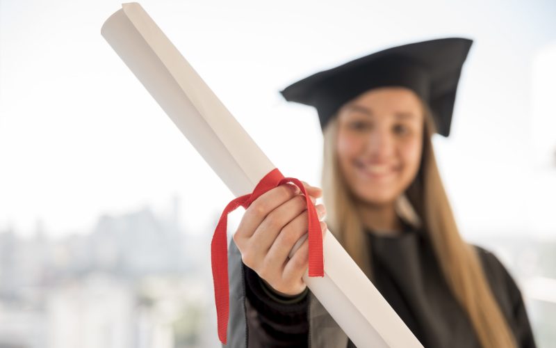 jovem-graduado-mostrando-dela-certificado-close-up